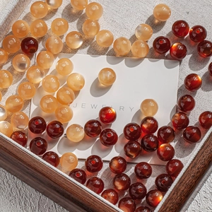 Macro shot of 10mm cat-eye resin beads in amber and deep red for jewelry DIY