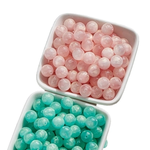 Pink and cyan cat eye glass beads for DIY jewelry making in white ceramic bowls
