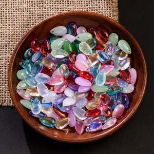 Macro shot of colorful teardrop glass beads in a wooden bowl for DIY jewelry making