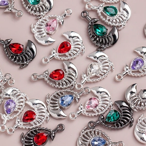 Macro detail of alloy scorpion pendants with teardrop crystals in various colors for DIY jewelry