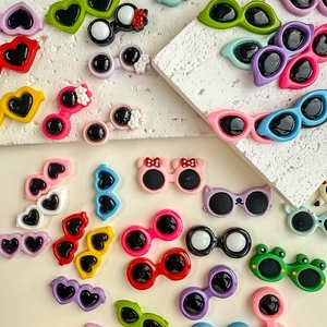 Macro detail of colorful resin heart and cartoon glasses charms for DIY crafts
