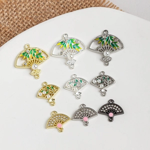 Detail of fan-shaped DIY jewelry charms with enamel bamboo leaves and pearl inlay