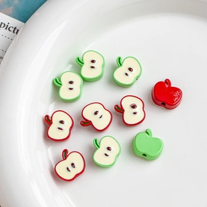 Vue macro de perles en forme de pomme rouge et verte pour bijoux DIY et chaînes de téléphone