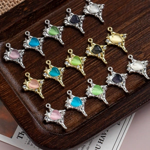 Detail of silver and gold heart cross pendants with colorful stones on wooden tray