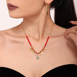Christmas themed necklace with red beads and golden enamel holiday pendants on model neck