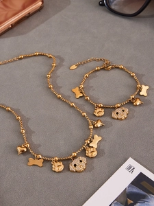 Golden necklace and bracelet set featuring sparkling CZ puppy and bone charms