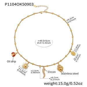 Detail of gold stainless steel necklace with red ladybug, heart, and zircon horn charms