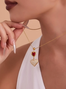 Dettaglio della collana a doppio cuore dorata con gemma rossa e cristalli di zircone pavé