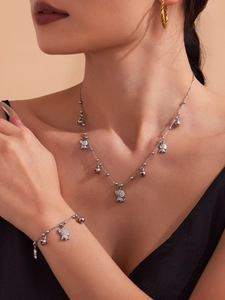 Détail de pendentifs éléphant avec zircone sur collier et bracelet portés par un mannequin