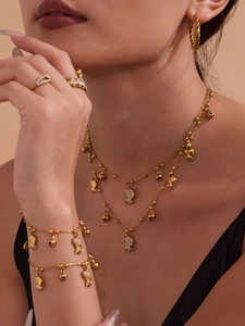 Gros plan sur ensemble de bijoux dorés 18k avec pendentifs éléphants et oxydes de zirconium