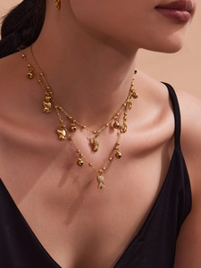 Détail du collier double rang plaqué or 18k avec cloches de chiot et breloques en zircon
