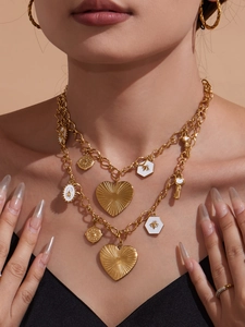 Détail du collier à chaînes dorées avec pendentifs en cœur et breloques abeilles en émail