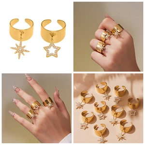 Detail of gold-plated wide open rings featuring dangling star charms with zircon stones
