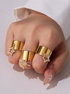 Detail of three 18k gold plated stainless steel wide rings with zircon star charms