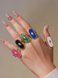 Détail de bagues ovales en émail multicolore avec plaquage or 18 carats sur un mannequin
