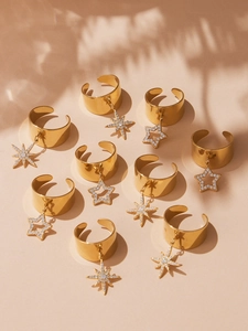 Detail of 18k gold plated wide rings featuring North Star and star charms with zircons