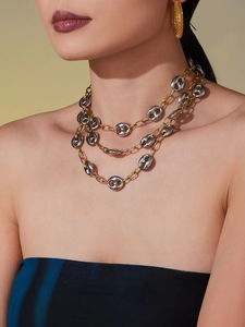 Close-up of layered two-tone pig nose link chain necklace with gold and silver finish