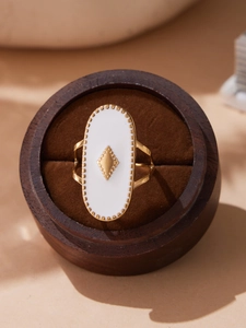 Détail d'une bague ovale émaillée à carreaux dans un écrin à bijoux en bois
