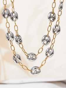 Detail of two-tone gold and silver pig nose link necklace with polished chain texture