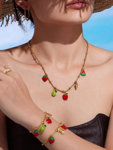 Detailed view of colorful fruit enamel pendants on gold stainless steel jewelry set