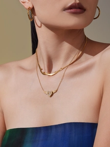 Nahaufnahme der goldenen doppellagigen Halskette mit Herz-Engelsflügel-Anhänger und Kette