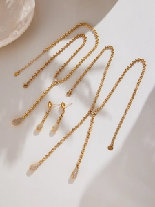 Close-up of gold stainless steel bead chain with teardrop zircon pendant jewelry set