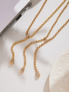 Detail of 18k gold plated bead chain necklace featuring a teardrop zircon pendant