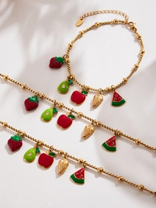 Detail of gold stainless steel charm bracelets with colorful fruit oil drop pendants
