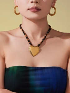 Polished gold heart pendant with leopard print scarf cord and textured hoop earrings