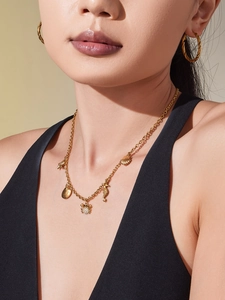 Détail du collier océan doré avec pendentifs coquillage, hippocampe et crabe sur mannequin