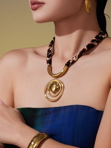 Detail of leopard print silk scarf necklace with gold heart pendant and matching jewelry set