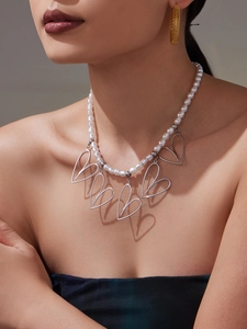 Dettaglio macro della collana di perle fatta a mano con ciondoli a cuore e orecchini mesh
