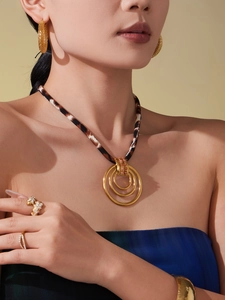 Detail of leopard print silk scarf necklace with gold rings and matching jewelry set