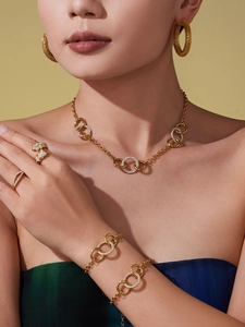 Vue détaillée du collier et du bracelet dorés avec zircons entrelacés sur mannequin
