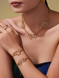 Détail de parure collier et bracelet en or avec cercles entrelacés sertis de zircons