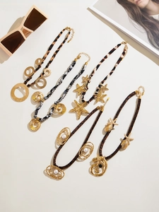 Detail showing assorted gold star and pearl pendants with leopard print silk scarves