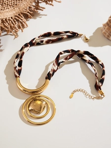 Detail of leopard print scarf necklace with golden heart pendant and lobster clasp