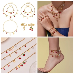 Detail view of colorful enamel fruit charms on golden bead chain jewelry set