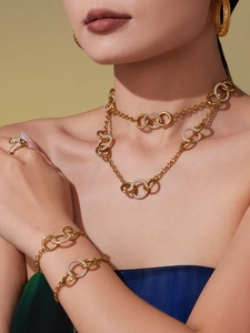 Détails de l'ensemble de bijoux dorés avec anneaux entrelacés et zircons