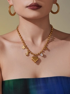 Détail du collier à billes plaqué or 18K avec pendentifs cœur, ours et zircon