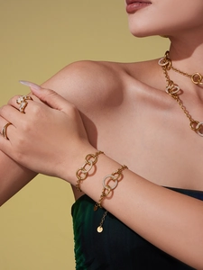 Détail d'anneaux entrelacés en or avec oxydes de zirconium sur collier et bracelet