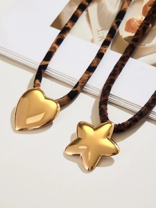 Detail of leopard print scrunchies with large gold heart and star shaped metal charms