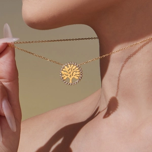 Élégant collier Arbre de Vie en acier inoxydable doré avec zircons, porté par un modèle