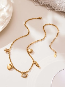 Détail du collier marin doré avec des breloques étoile de mer et crabe sur chaîne