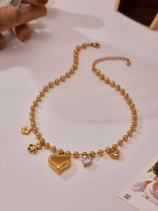 Vue détaillée du collier à perles plaqué or avec breloques d'ours et de coeurs