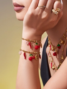 Détails de colliers superposés et breloques plaqués or 18K sur le cou et les mains