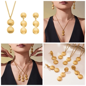 Detailed view of golden spiral textured pendant necklace and matching earring set