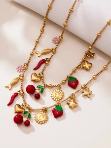 Détail du collier en perles dorées avec pendentifs colorés en émail fraise et cerise