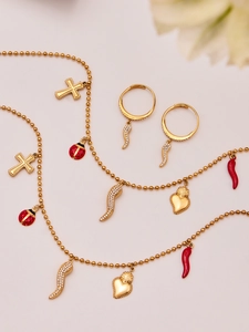 Detailed view of gold necklace with charms including cross, ladybug, and heart pendants