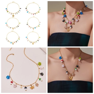Macro detail of colorful resin flower and mushroom charms on a gold zircon necklace